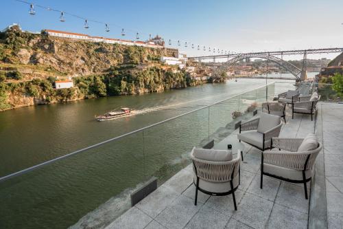 a row of chairs sitting next to a river at Eurostars Porto Douro in Porto