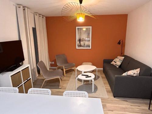 ein Wohnzimmer mit einem Sofa, einem Tisch und Stühlen in der Unterkunft Bel appartement climatisé 2 chambres à 20m du Vieux-Port in Marseille
