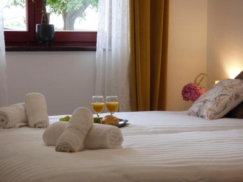 a hotel room with two glasses of wine on a bed at Seoska vila Vallis Aurea in Kaptol