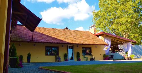 mały żółty dom z czerwonym dachem w obiekcie Seoska vila Vallis Aurea w mieście Kaptol