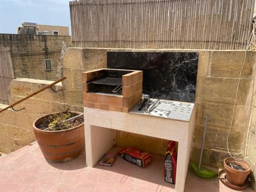 a barbecue grill on top of a building at Razzett Warda B&B in Għasri