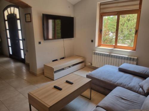 a living room with a couch and a flat screen tv at Hauzify I Casa Palamosina in Palamós