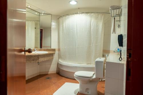 a bathroom with a toilet and a sink and a tub at City Palace Hotel in Dubai