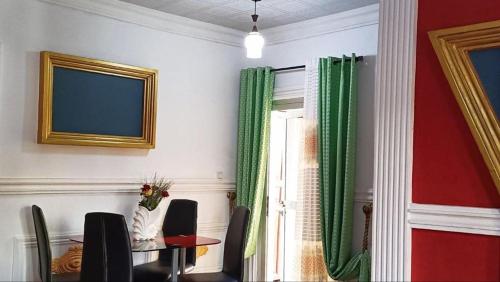 a dining room with a table and chairs and a window at Residence Seka in Mbalngong