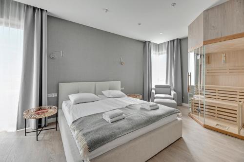 a bedroom with a large bed and a chair at GRANO HOTEL Solmarina in Wiślinka