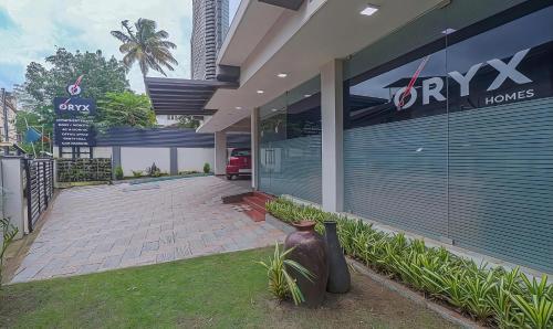 a store front of a building with a vase at Oryx Home The Business Class Hotel in Kakkanad
