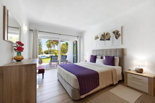 a bedroom with a bed and a sliding glass door at Apartamento Navegador in Sagres