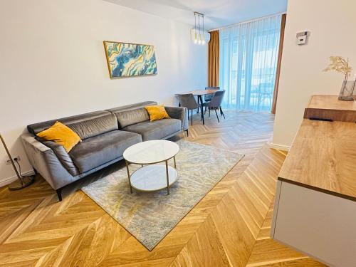 ein Wohnzimmer mit einem Sofa und einem Tisch in der Unterkunft Bel Dom - The Central, spacious 2 rooms luxury apartment in Cluj-Napoca
