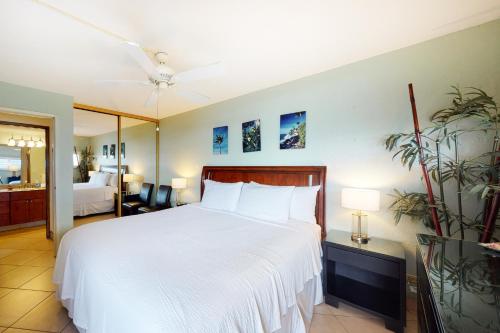 a bedroom with a large bed with a white bedspread at Island Sands Resort 111 in Wailuku