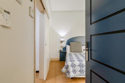 a small bedroom with a bed and a door at nüa cicerone in Seville