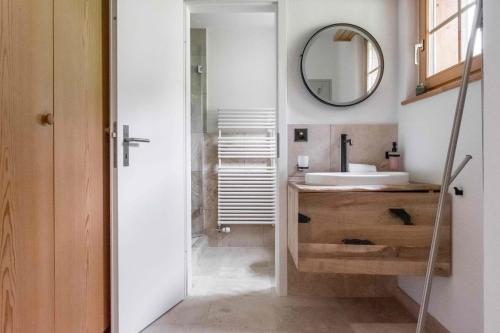 ein Bad mit einem Waschbecken und einem Spiegel in der Unterkunft Apartment Alpin DG - GRIWA RENT AG in Grindelwald