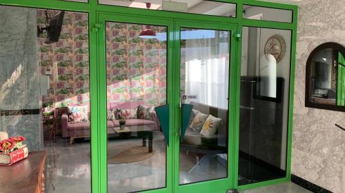 a green glass door in a living room with a couch at Apto. Singular en la Mancha Banco de Inversiones in Argamasilla de Alba