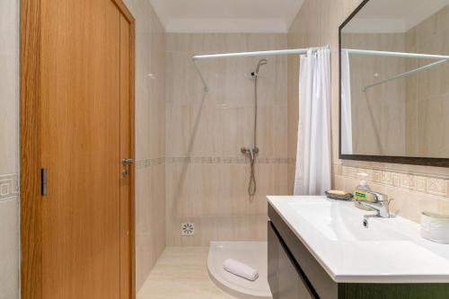 uma casa de banho com um chuveiro, um lavatório e um WC. em Casa de Mare em Albufeira