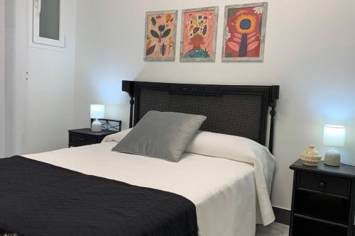 a bedroom with a black and white bed with two lamps at Apto. Singular en la Mancha Banco de Inversiones in Argamasilla de Alba