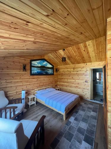 Lake stone house في صبنجة: غرفة نوم كابينة خشب بها سرير وتلفزيون