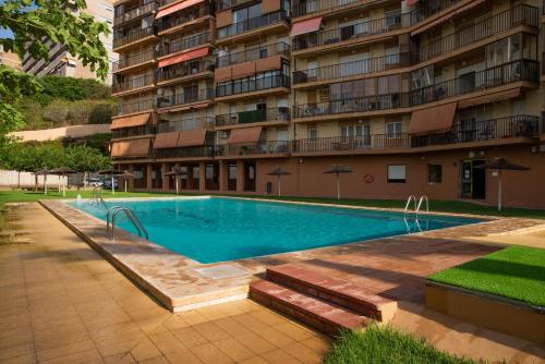 a swimming pool in front of a building at Myflats Premium Beach Front in Arenales del Sol