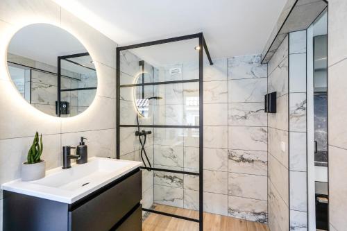 a bathroom with a sink and a shower at Beautiful Apartment With Loft in Delft