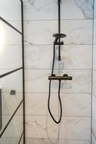 a shower with a hose hanging on a wall at Beautiful Apartment With Loft in Delft