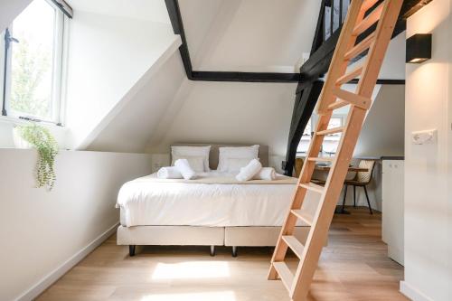 a bedroom with a bed and a ladder at Beautiful Apartment With Loft in Delft