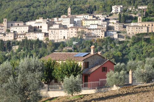 a village on a hill with trees and buildings at Country House Le Grazie in Serra San Quirico