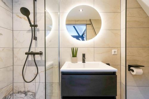 a bathroom with a shower and a sink and a mirror at Romantic 35m2 City Center Suite in Delft