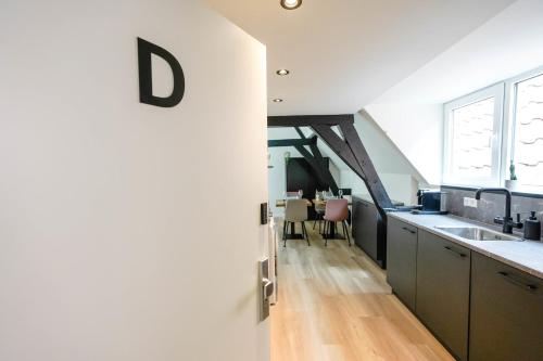 a kitchen with a white wall with the letter d on it at Romantic 35m2 City Center Suite in Delft