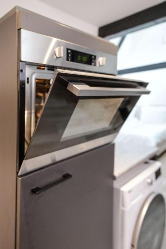 a kitchen with an oven and a washing machine at Romantic 35m2 City Center Suite in Delft