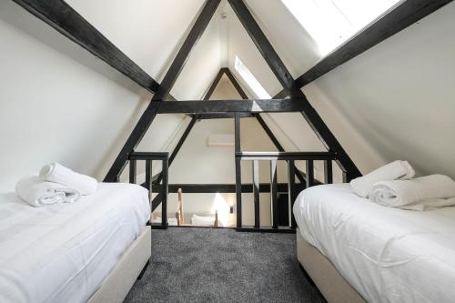 a attic bedroom with two beds and a window at Romantic 35m2 City Center Suite in Delft