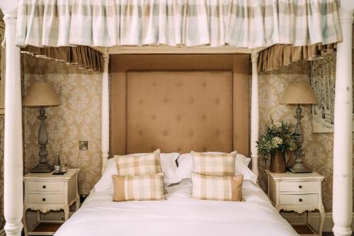a bedroom with a large bed with a canopy at Falcon Manor Hotel in Settle