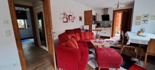 sala de estar con sillas rojas y mesa en Ferienwohnung Fichtler en Sankt Johann in Tirol