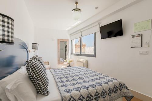 a bedroom with a bed and a flat screen tv at nüa cicerone in Seville