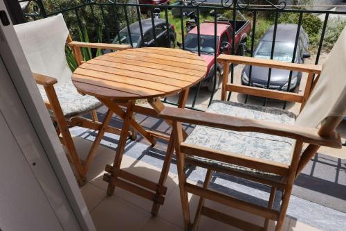 a wooden table and two chairs on a balcony at Al Mar in Skiathos Town