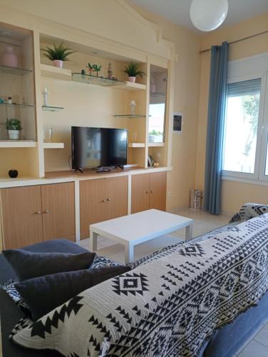 a living room with a bed and a tv at Peace and quiet Kremasti in Kremasti