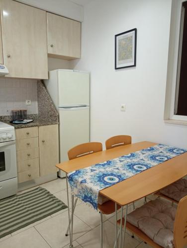 a kitchen with a table and a white refrigerator at Peace and quiet Kremasti in Kremasti