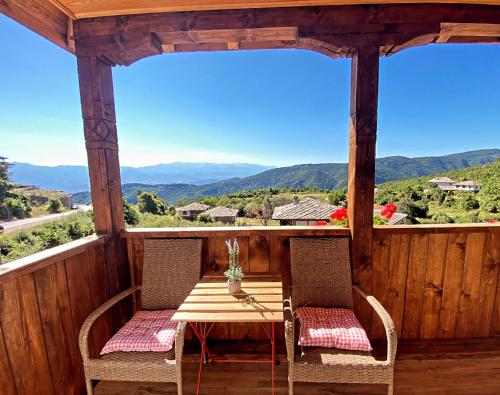 una mesa y sillas en un porche con vistas en Rooms in Leshten, en Leshten