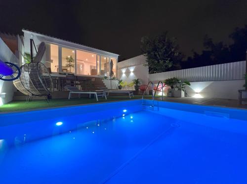 a swimming pool in front of a house at night at Central Beach Villa W/ Heated Pool, By TimeCooler in Cascais
