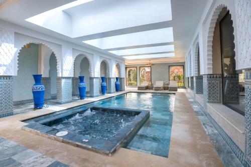 een binnenzwembad in een gebouw met blauwe vazen bij Janat Al Atlas Resort & Spa in Marrakesh