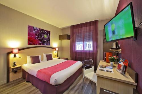a hotel room with a large bed and a flat screen tv at The Originals City - Hôtel Saint-Martial, Limoges Centre in Limoges