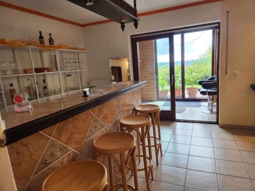 a bar with wooden stools in a kitchen with a view at Ferienhaus Brenda in Schillingsfürst
