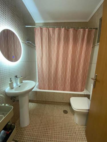 a bathroom with a sink toilet and a shower curtain at Konstantino's Apartment in Monemvasia