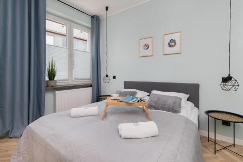 a bedroom with a bed with a table on it at Old Town Apartment Garncarska by Renters in Gdańsk