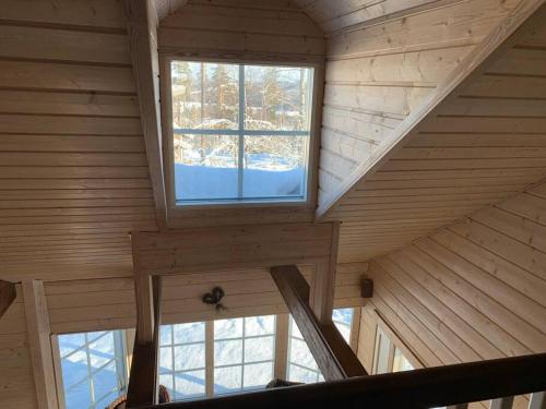 an attic room with two windows in a cabin at VILLA RIIHITONTTU MUURAME RIIHIVUORI in Muurame