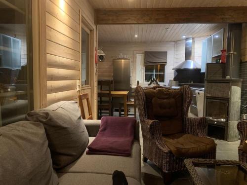 a living room with a couch and a kitchen at VILLA RIIHITONTTU MUURAME RIIHIVUORI in Muurame