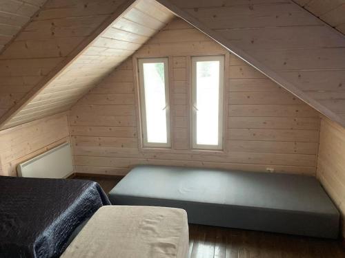 a attic room with two beds and two windows at VILLA RIIHITONTTU MUURAME RIIHIVUORI in Muurame
