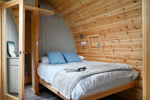 a bedroom with a bed in a wooden wall at Little Quarry Glamping Bed and Breakfast in Tonbridge