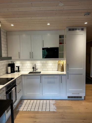 a kitchen with white cabinets and a sink at Nice apartment on Geilotunet, Close to city center in Geilo