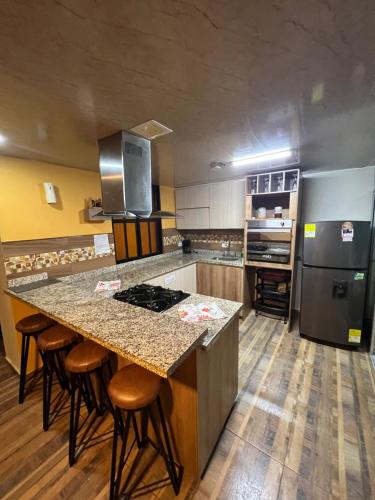 a large kitchen with a large island with bar stools at Apartamento de lujo en Dosquebradas #201 in Dosquebradas