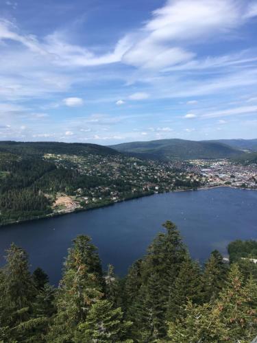 a view of a large lake with a city at chalet de la Cercenée in Gérardmer