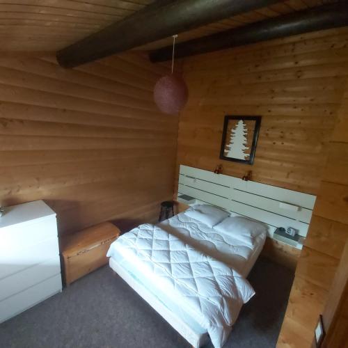 une chambre avec un lit dans une cabane en rondins dans l'établissement chalet de la Cercenée, à Gérardmer