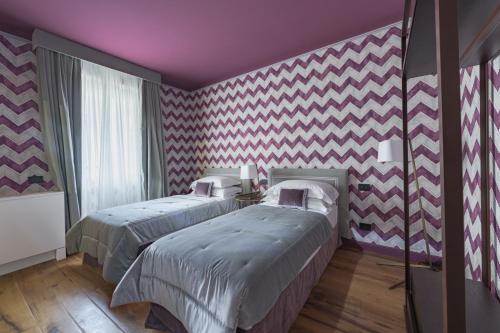 two beds in a room with pink and white stripes at Apartments Florence - Palazzo Signoria luxury Apartments 11-Medusa in Florence